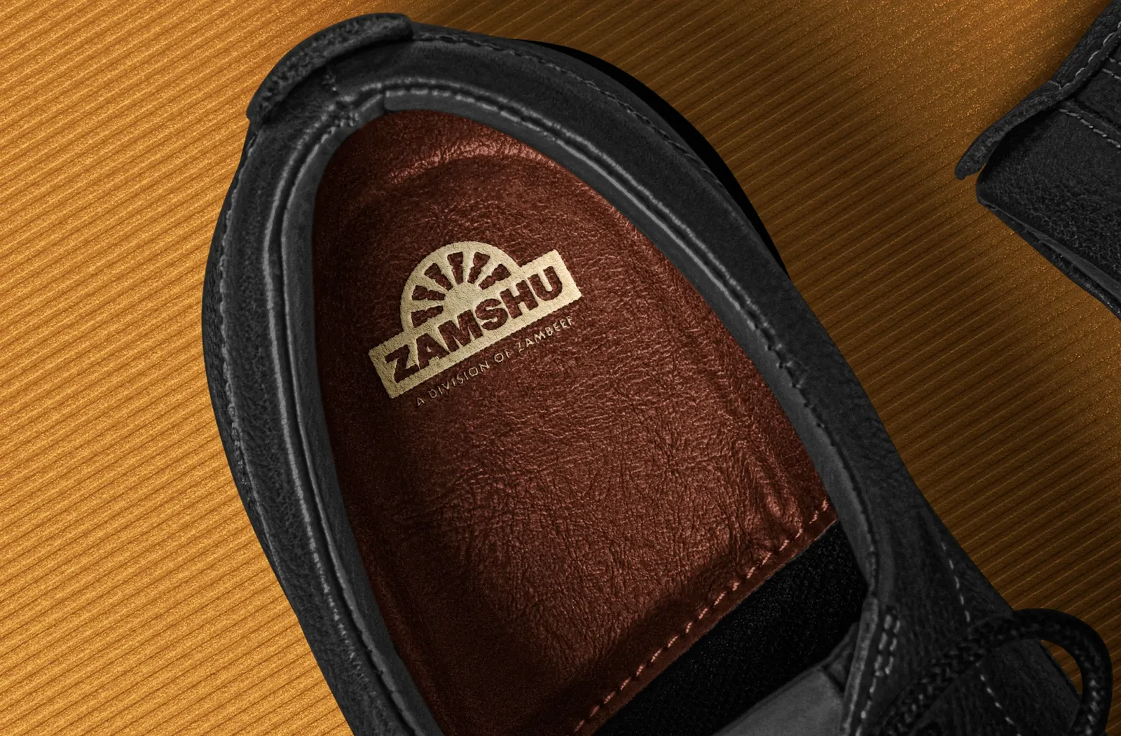 A black shoe with the ZAMSHU logo printed in bronze on the insole.