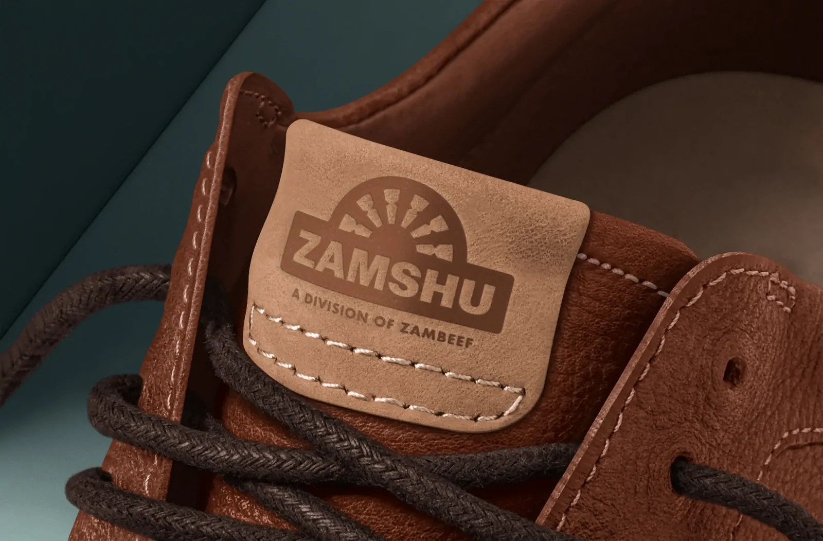 A brown leather shoe with a debossed ZAMSHU tongue label.