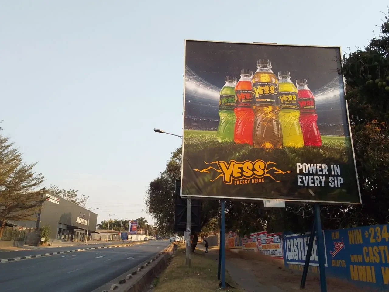 A large YESS billboard at the side of a main road.