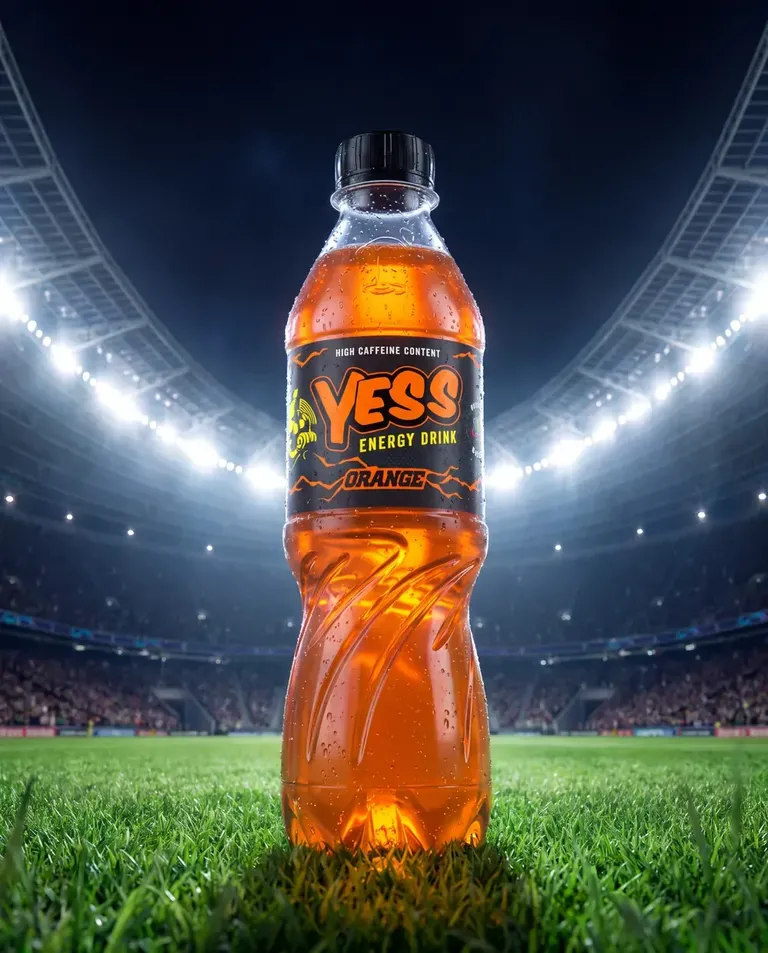 A YESS Orange bottle glowing on a floodlit stadium pitch.