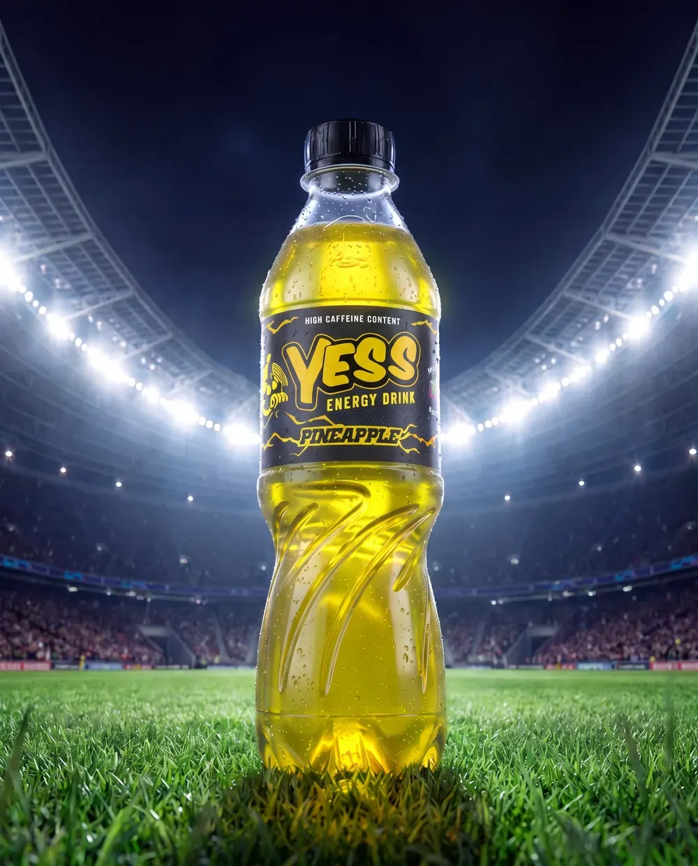 A YESS Pineapple bottle on a floodlit stadium pitch.
